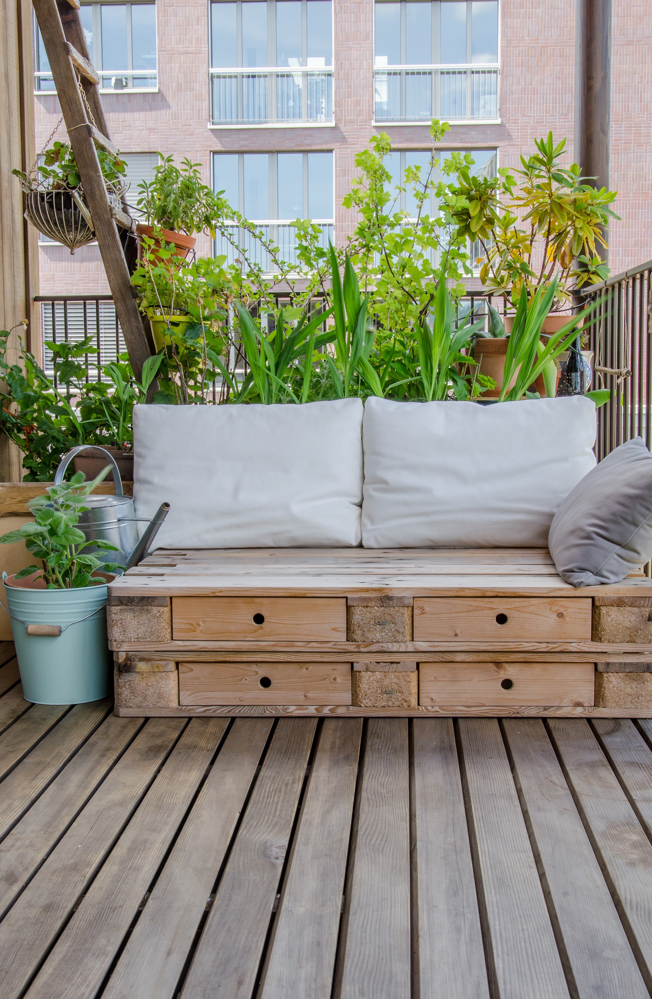 Ansicht einer Palettensitzecke auf einem begrünten Balkon