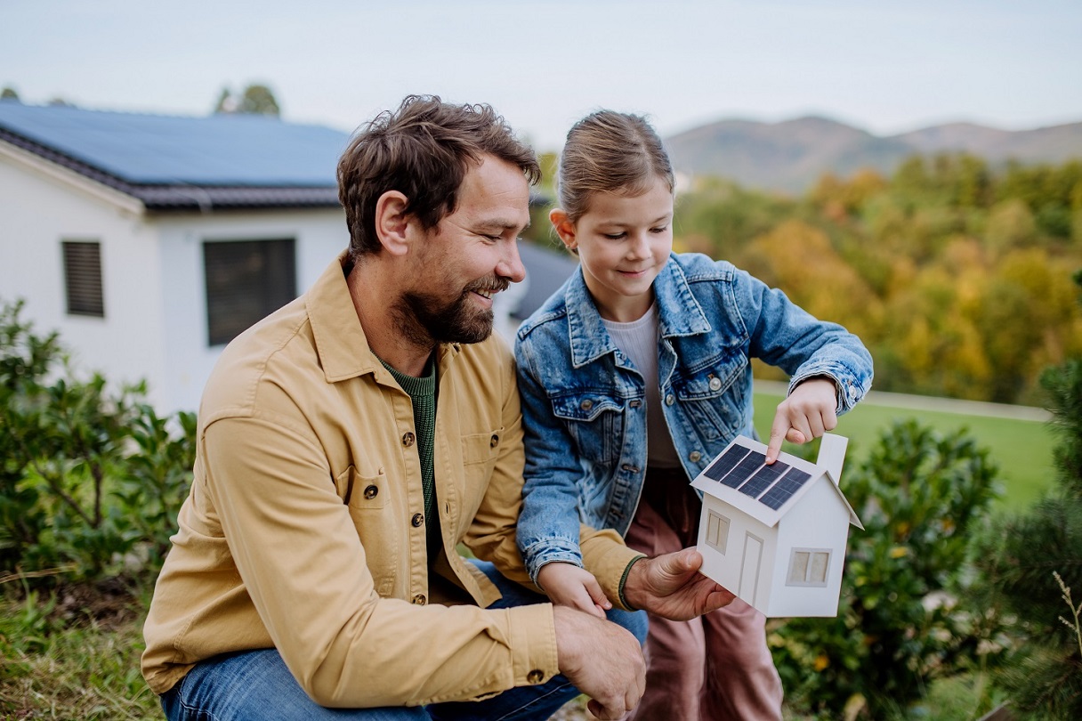 Vater mit Tochter an Solar-Modellhaus